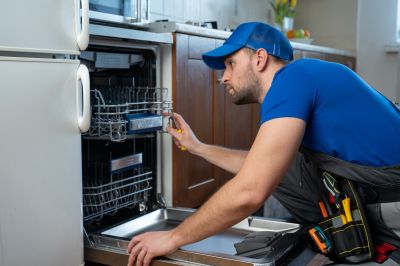Technician testing microwave after repair