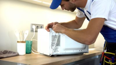 Technician inspecting a microwave